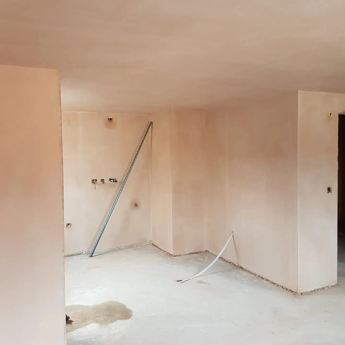 An empty room with a ladder in the middle of it.
