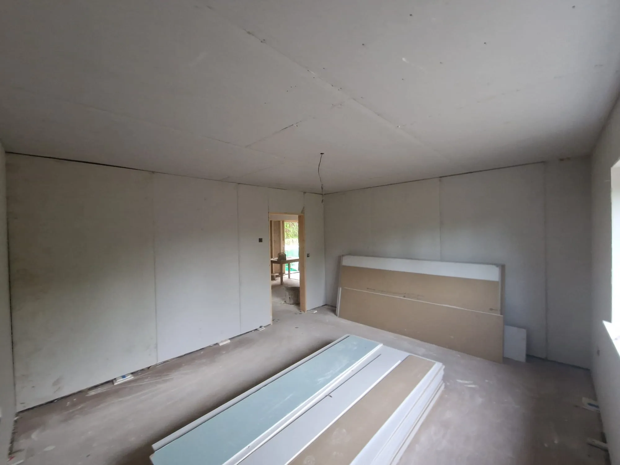 An empty room with a bed and a window.