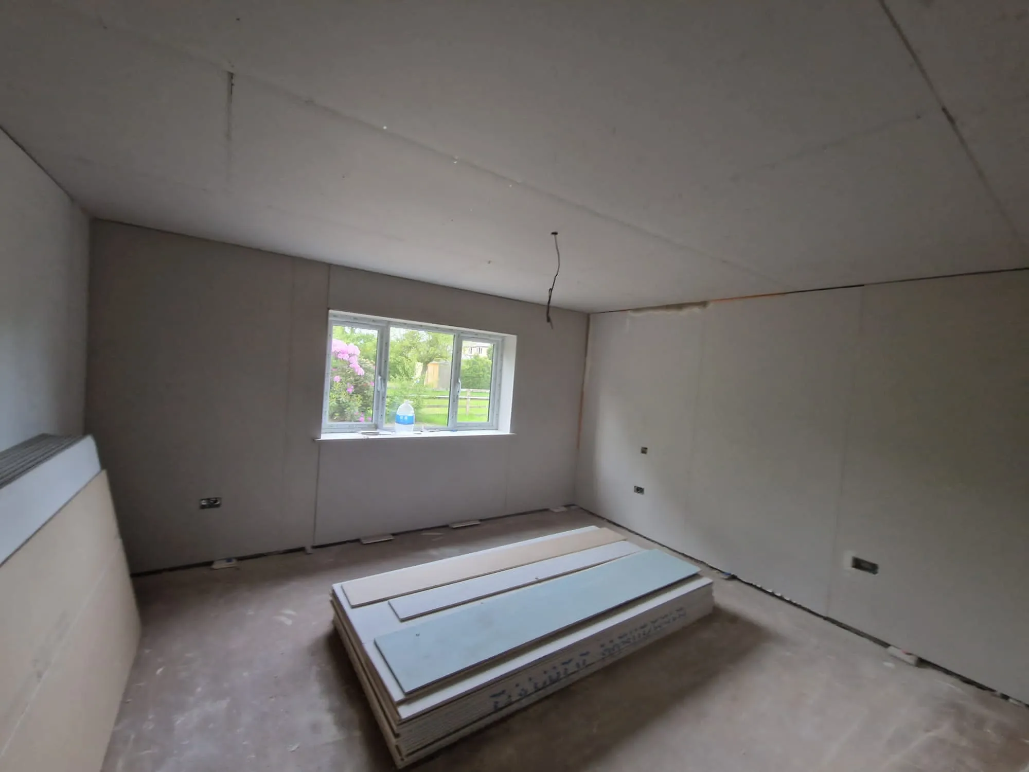 An empty room with a window in the middle of it.